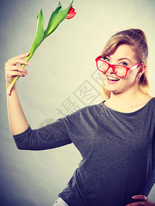 纳迪女孩挥舞花朵带着郁金香的眼镜笑年轻女士背景图片