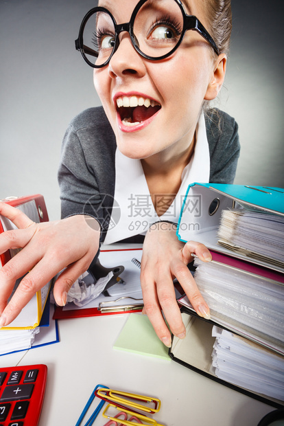 工作期间的面部表情疯狂满意的会计女商人周围都是文件和办公室的文件夹疯狂满意的会计师女商人图片