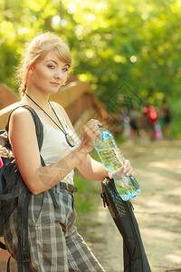 探险旅游享受暑假年轻旅游登山女青年在森林小路上背着水瓶图片