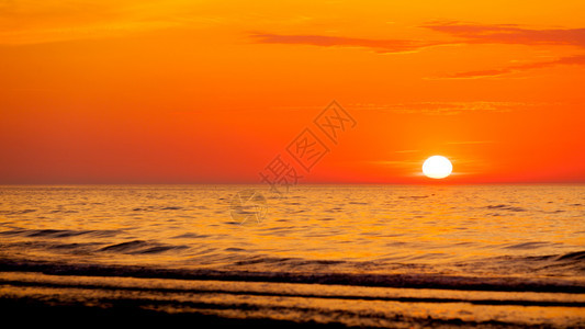 海水的日落温暖橙色和红图片