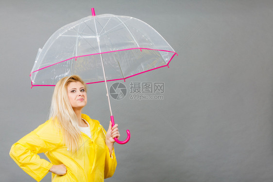 雨天时心情良好金发妇女快乐穿着黄色雨衣拿透明伞戴雨衣伞穿雨衣的妇女快乐穿着透明伞图片