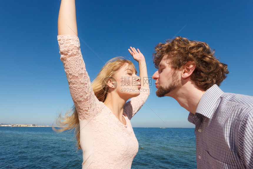 相爱的金发美女英俊的胡子男享受浪漫的约会吻户外宽阔