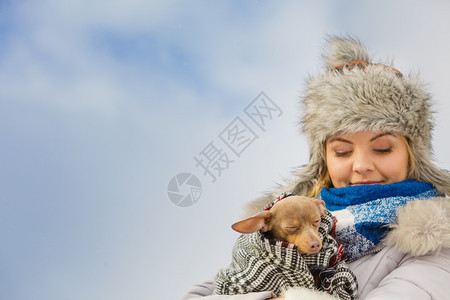 年轻女用温暖的毛毯围巾裹住她最好的朋友小狗在寒冷的冬天温暖他动物保护存收养概念妇女拥抱在寒冷的一天温暖她狗图片