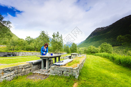 在斯堪的纳维亚欧洲诺韦吉山区旅行妇女吃大自然的午餐在挪威山区旅行妇女吃大自然的午餐图片