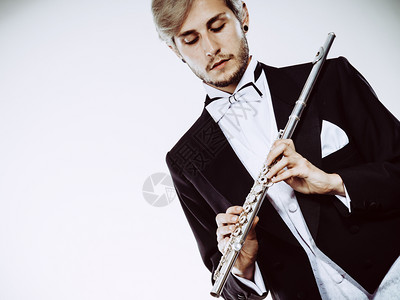 穿尾衣的年轻优雅男子拿着乐器穿尾衣的男风笛手拿着长图片素材