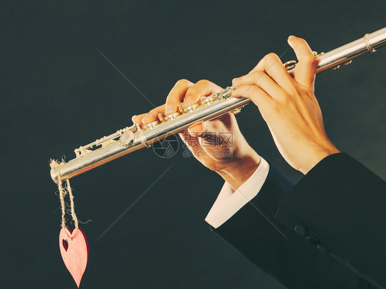 情人节爱旋律概念长笛音乐演奏人吹风的音乐演奏者男手拿着乐器和红心关上门男吹风曲手拿着笛子和心爱旋律图片