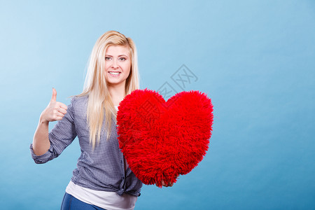 爱浪漫情人节礼物概念快乐的女士带着大红毛发枕头心型快乐的女士抱着红枕头心型图片