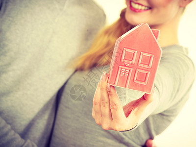 拥有房产的家庭权房地产概念人与房屋模型两人持有房屋符号图片