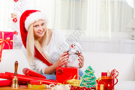带圣诞帽的雪人圣诞时间概念带着圣克拉斯的金发少女快乐玩着小雪人具背景