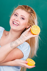 怀着两半黄柠檬柑橘水果的少女手握两半黄柠檬柑橘水果吃着深绿色营养健康饮食图片