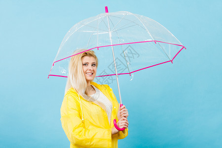 雨天时心情良好金发妇女快乐穿着黄色雨衣拿透明伞戴雨衣伞穿雨衣的妇女快乐穿着透明伞图片