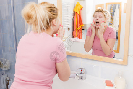 敏感干皮肤问题的概念害怕的女人在水槽下洗脸害怕的女人在水槽下洗脸图片