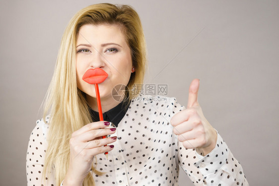 欢快的女子乐手握着假嘴唇欢乐的相片和嘉年华有趣的配件概念欢乐的女子图片