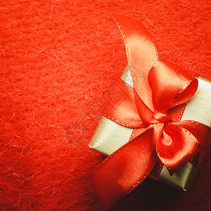 节日现圣诞节概念小金盒带有礼品装饰弓红背景带复制空间图片