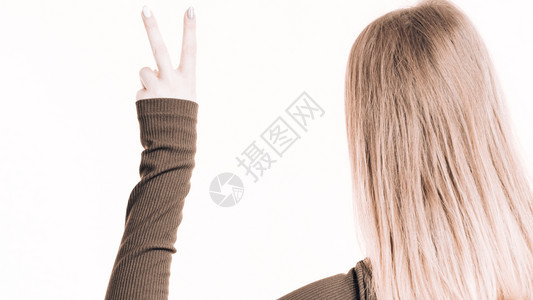 白色背景的金发女子背影展示和平用手指显示良好的积极姿态图片