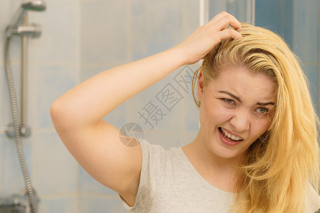 金发女人在洗手间里看着自己身上有油的头发有问题皮抓伤自己脱衣问题金发女人有问题头发背景图片