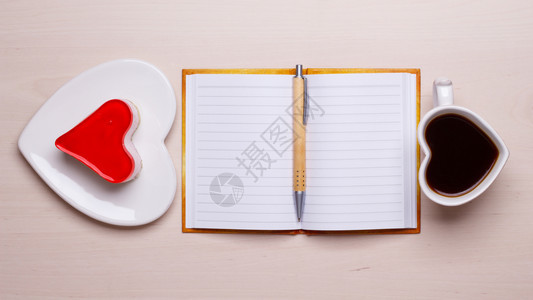 咖啡杯果冻蛋糕形式为心脏和纸上空白笔记本桌上有最视图复制文本空间图片