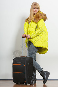 带着手提箱穿温暖外套的年轻快乐女人美丽的金发女游客旅行孩游图片