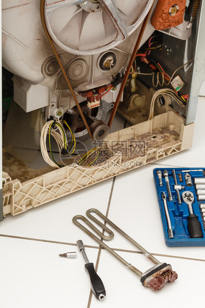 机械工业家用电气工程概念修理期间洗涤机用加热器除去断裂的洗衣机工具组旁边修理期间洗涤机图片