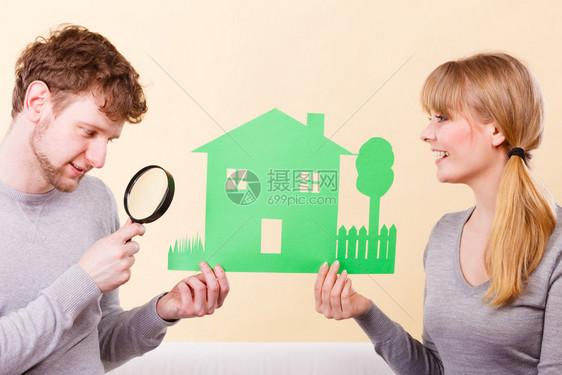 房屋地产家庭未来财务概念年轻夫妇关注细节只有已婚男人和女用放大玻璃来靠近房屋模型看图片