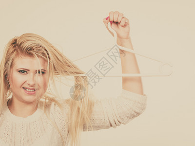 衣柜配件发型发型和销售概念金发女人把头发放在衣架上衣架上拿头发的女人图片