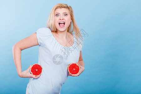 女微笑的孩将两半红葡萄果柑橘握在手中蓝色上健康饮食品暑假的乐趣概念女将葡萄果握在手中图片