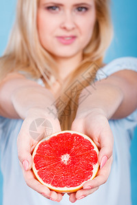 将一半的红葡萄果柑橘握在手含蓝色的红葡萄薯柑橘水果中健康饮食品暑假概念妇女将葡萄果柑橘水握在手中图片