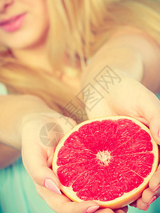 红葡萄油柑橘水果的一半放在女手上健康饮食体重丧失概念红葡萄油柑橘水果的一半放在人类手中图片