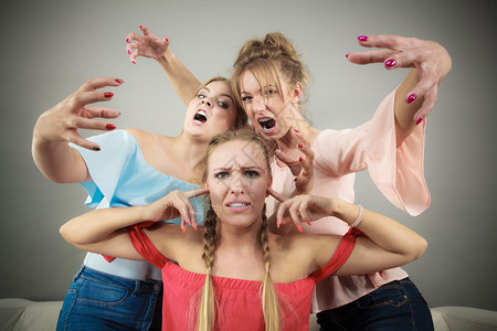 妇女受到两个朋友的欺凌妇女争吵愤怒的女孩对朋友或妹大喊叫友谊困难争斗和嫉妒问题妇女受到两个欺凌图片