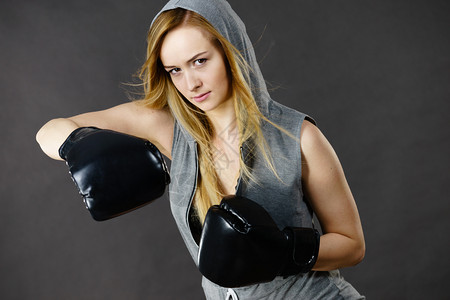 穿旗袍戴头罩的年轻女子打拳击金发美女戴黑色拳击手套运动和健身权力