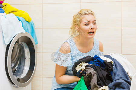 卫生间里有一堆脏衣服洗和被损坏的洗衣机不快妇女勤奋工作家务活洗脏衣服的不快女孩图片