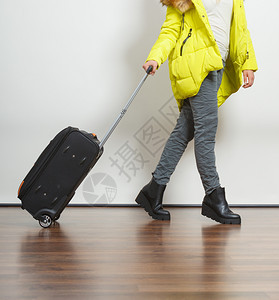穿着暖和外套手提箱的女人旅游郎图片