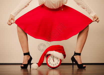 穿着高跟鞋和闹钟的女子穿着圣达克萨斯帽子圣诞时节概念穿着高跟鞋的女子带着闹钟的女子圣诞节图片