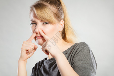 污秽卫生净垃圾气味概念金发女孩拿着鼻子年轻女士拿着恶心的臭味黄发女孩拿着鼻子图片