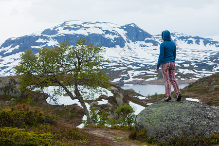 旅行自由游女客在挪威看风景山地和雪覆盖的山丘在挪威享受山地风景的旅游女客图片