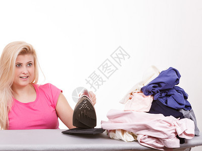 做家务照顾衣服概念快乐的女士站在船身后面衣着堆积如铁快乐的女士做熨衣服图片
