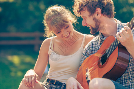 冒险旅游一起享受暑假年轻夫妇旅游者在露营时玩吉他图片