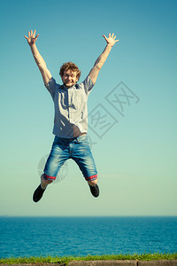 无忧虑的年轻人跳过海水快乐的男孩夏天和自由图片
