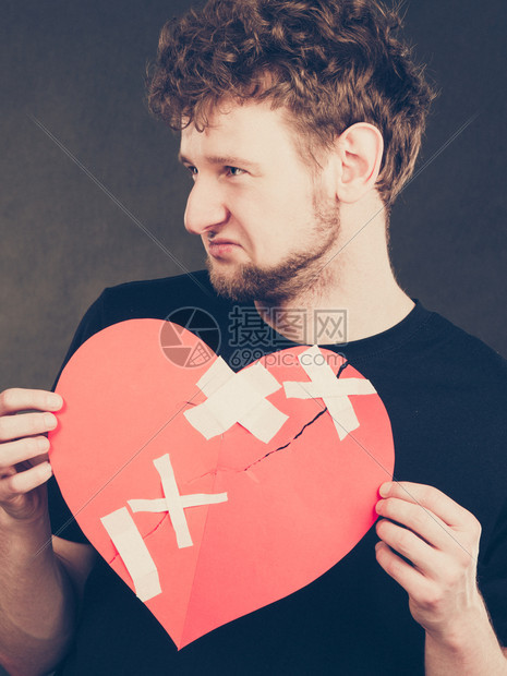 悲伤的年轻男人被石膏粘住的红心失去爱情人节图片