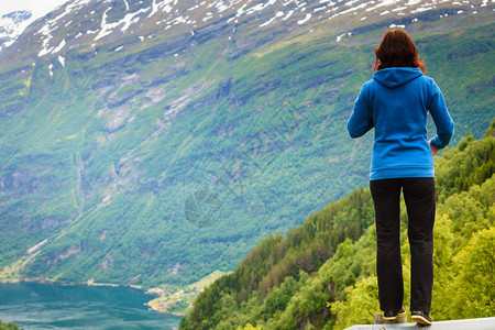 旅游概念妇女欣赏挪威的峡湾和美丽山地景观图片