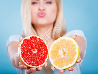 人手里拿着香甜可口的柑橘类水果红绿相间的柚子拿着红绿柚子的女人