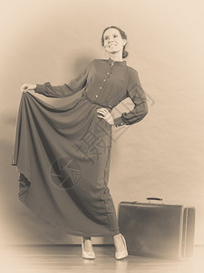女人的旧式长的深色袍旧式手提箱照片塞皮亚图片