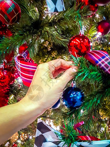 女人手工装饰圣诞树不同种类的品图片