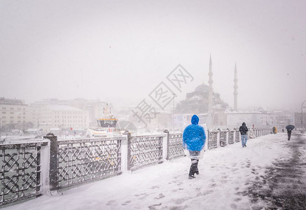 新清真寺在背景上2017年月日土耳其伊斯坦布尔冬天人们在雪加拉塔桥上行走图片