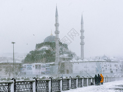 土耳其伊斯坦布尔207年1月日20年不明身份的男子在土耳其伊斯坦布尔最猛烈降雪的加拉塔桥捕鱼图片