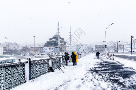 土耳其伊斯坦布尔207年1月日20年不明身份的男子在土耳其伊斯坦布尔最猛烈降雪的加拉塔桥捕鱼图片