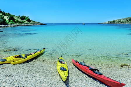 克罗地亚Sibenik的克罗地亚公园得里海克罗地Sibenik的克罗地亚得里海公园Kornati岛湾蓝天和海背景的滩上黄独木舟和图片