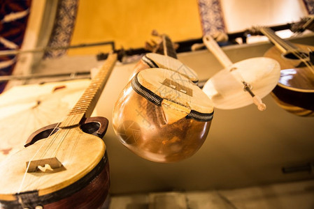 许多木制Baglama传统弦乐器挂在供出售的商店展厅墙上伊斯坦布尔大集市的背景图案许多木制的Baglama传统弦乐器图片