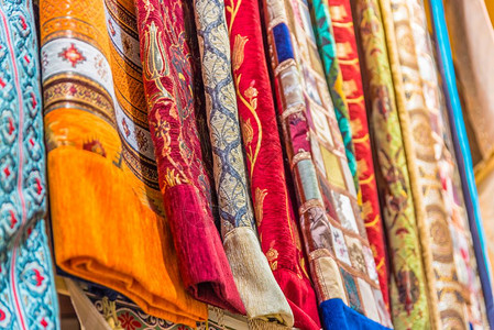 羊绒披肩传统多彩丝绸卡什米尔头巾或披和织物由土耳其伊斯坦布尔集市摊铺的堆叠背景构成丝绸卡什米尔头巾或由堆叠组成的围巾和织物背景