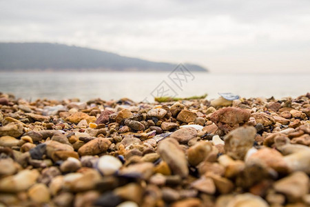 不同形状和大小的多彩海滩碎石背景以海和天空为背景选择焦点不同形状和大小的多彩海滩碎石背景图片